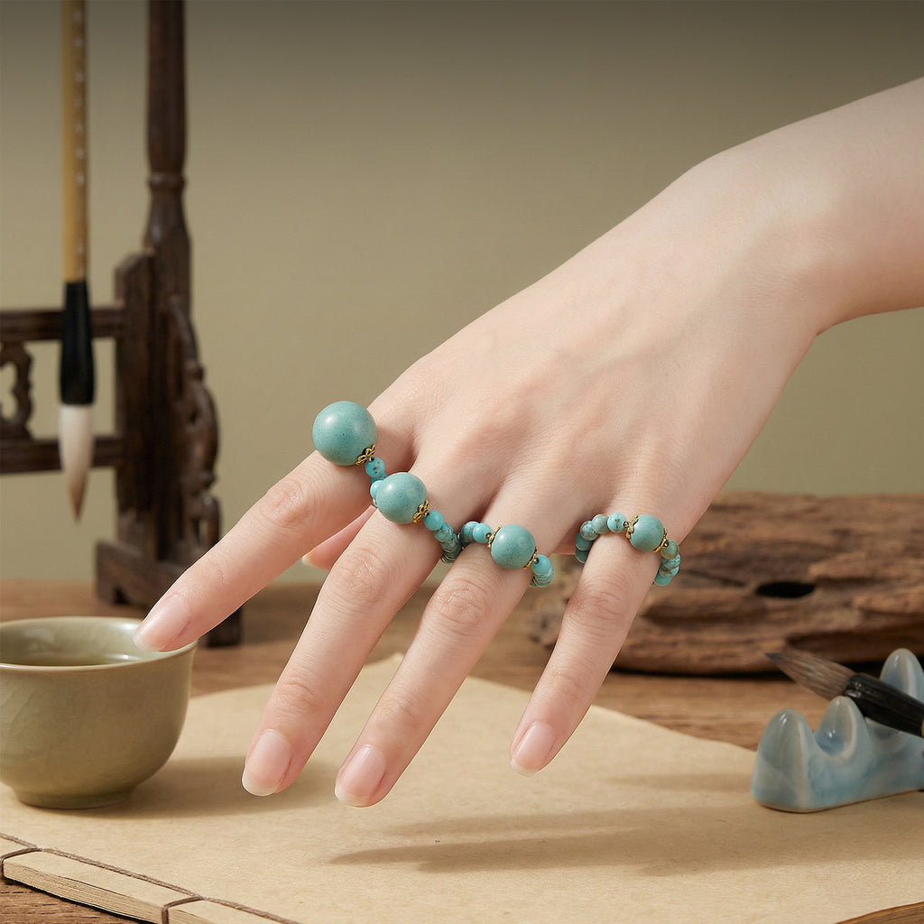 Incense bead rings worn stacked on a hand