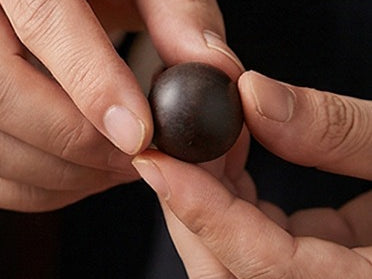 A single bead rolled and shaped between two fingers
