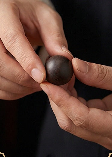 A single bead rolled and shaped between two fingers