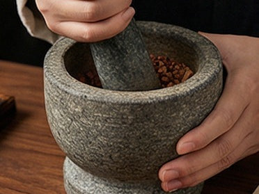 Botanicals ground down in a stone mortar and pestle