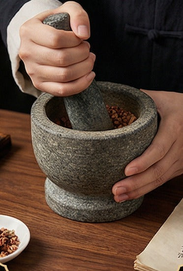 Botanicals ground down in a stone mortar and pestle